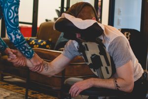 Seated massage session at Shift Workspaces showcasing wellness amenities available at Shift Workspaces Denver and Littleton.