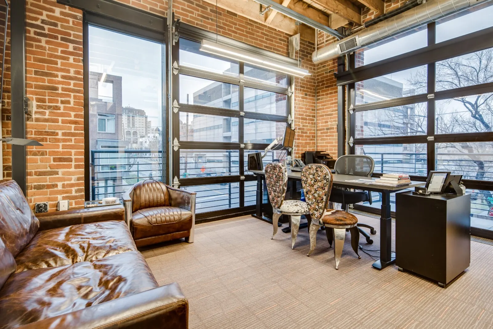 Stylish private office at Shift Workspaces with exposed brick, modern furnishings, and natural light—designed for professionals seeking a flexible and productive work environment in 2025.