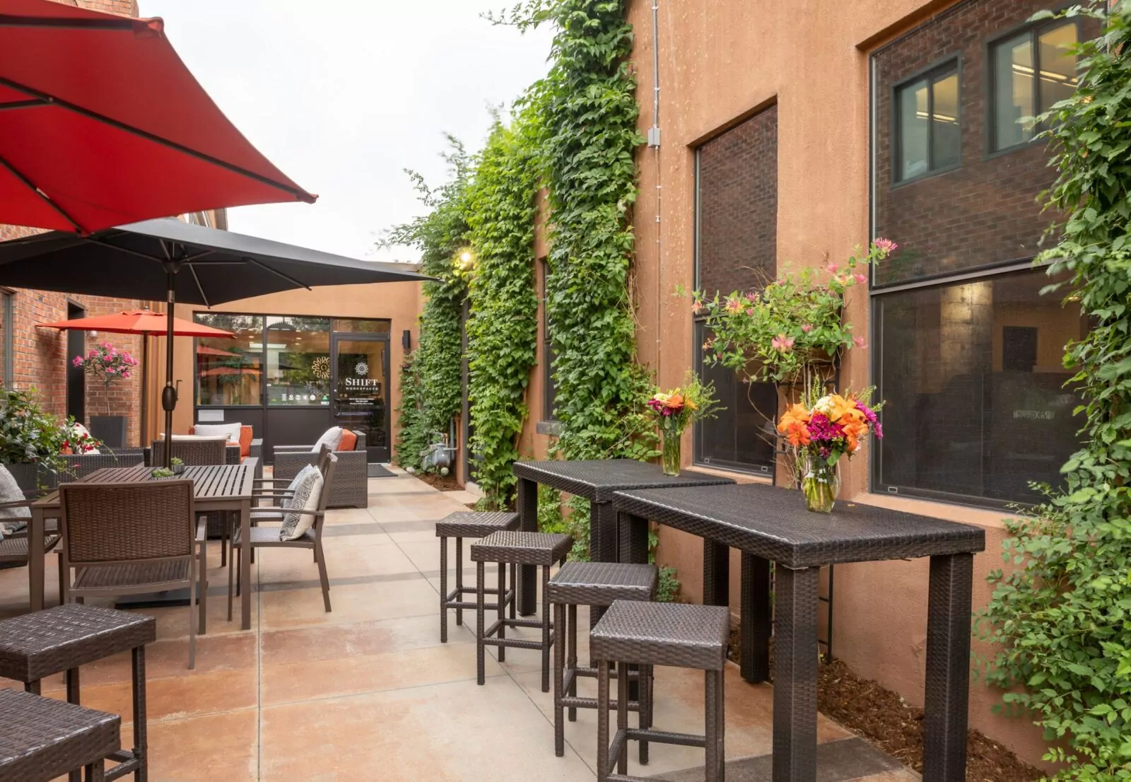 Tranquil courtyard at Shift Workspaces Corona with lush greenery and comfortable outdoor seating for work and relaxation.