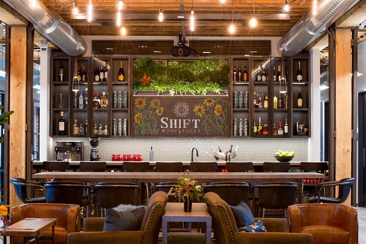 Coworking community table adjacent to the open bar, adorned with living plant wall and chalk art-resized