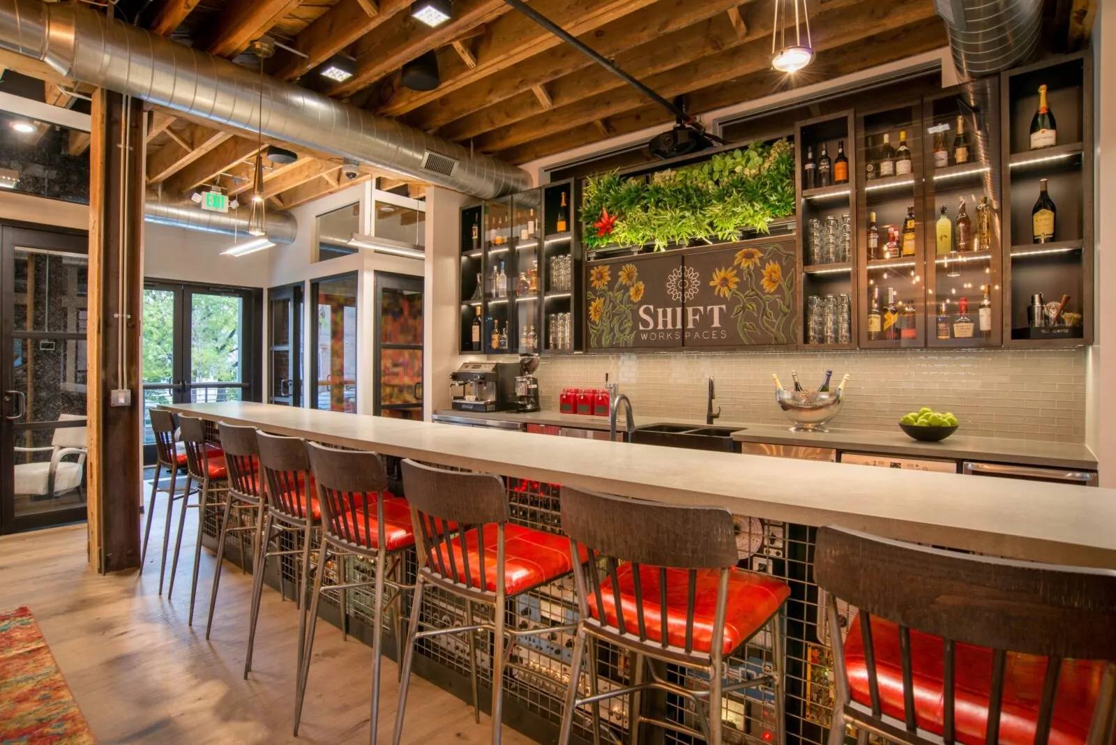 Fully stocked bar with living plant wall and chalk mural created by local artist, Justin Wood