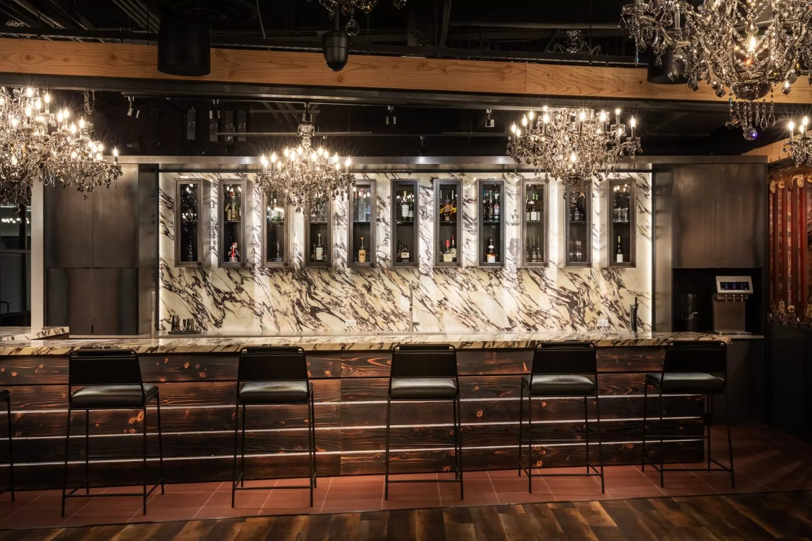 Sophisticated bar area at Shift Workspaces with marble countertops, elegant lighting, and modern barstools