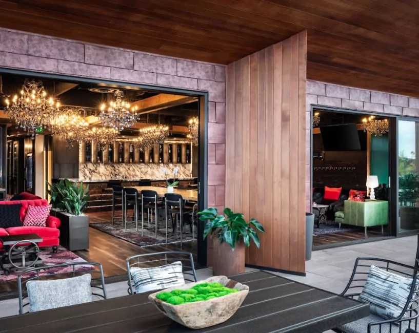 Elegant indoor-outdoor lounge at Shift Workspaces featuring a stylish bar, modern seating, and warm ambient lighting