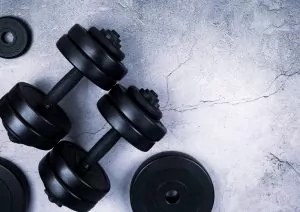 Black dumbbells on concrete background promoting fitness at Shift Workspaces Denver and Shift Workspaces Littleton.