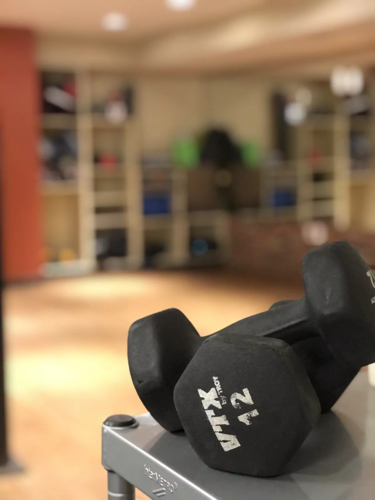 Shift Workspaces fitness center with a pair of VTX dumbbells in the foreground and workout equipment in the background