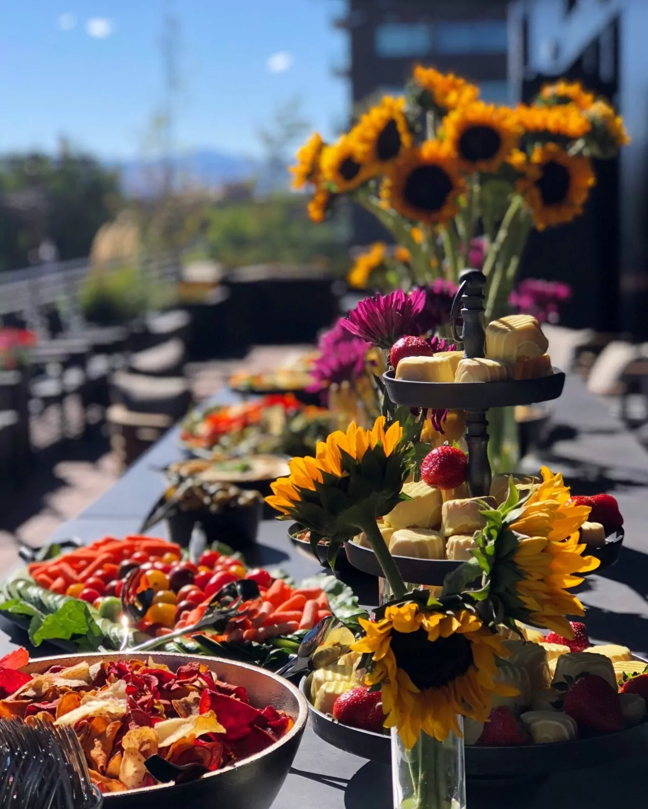 Outdoor event setup of a long table filled with snacks showing community gatherings at Shift Workspaces Denver and Littleton.